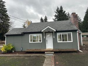 a small grey house with a white door at Relaxing and family friendly in Lacey