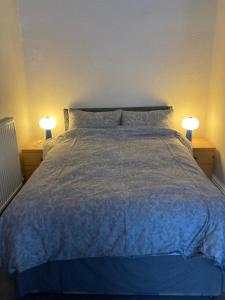Un dormitorio con una cama con dos lámparas sobre dos mesas. en Gilmore Flat, en Edimburgo