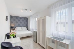 a bedroom with a bed and a desk and a window at Leokadia przy plaży kwatery prywatne in Mielno +20 photos