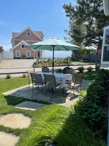 un tavolo con sedie e un ombrellone in un patio di Charming Beach Cottage a Westbrook