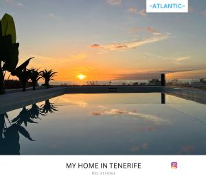Una imagen de una puesta de sol sobre una piscina. en -ATLANTIC- by myhomeintenerife, Luxury Private heated pool, en Palm-mar