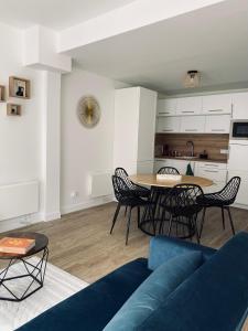 Una sala de estar con un sofá azul y una mesa. en Les Gites de Saint Thierry, en Reims