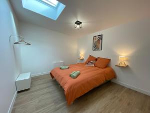 1 dormitorio con 1 cama con sábanas de color naranja y 2 lámparas en Les Gites de Saint Thierry, en Reims
