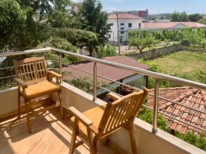 a balcony with two chairs and a table at Triena Rooms in Fier