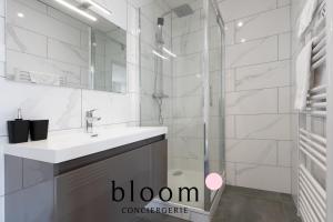 a white bathroom with a sink and a shower at Le cocon Place du Marché Nancy coeur de ville in Nancy