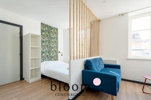 a bedroom with a bed and a blue chair at Le cocon Place du Marché Nancy coeur de ville in Nancy +7 photos