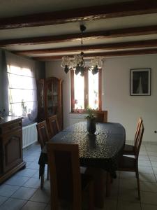 jadalnia ze stołem i krzesłami oraz oknem w obiekcie Bienvenue en Alsace w mieście Huttenheim