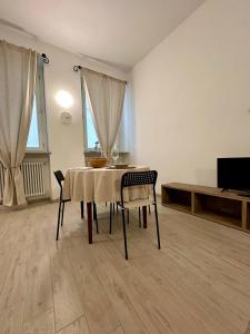 Un comedor con mesa y sillas y un televisor. en L'Angolo Rosa, en Casale Monferrato