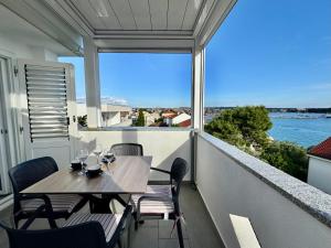 a table and chairs on a balcony with a view of the water at Emanuela 1 in Novalja