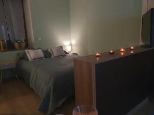a bedroom with a bed and a television and candles at La BK'ne studio 2 à 4 personnes in Villeneuve-en-Retz