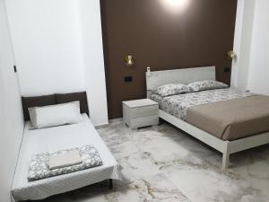 a bedroom with two beds and a night stand at SOGNi DOLCI in Vado Ligure