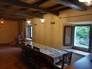 a dining room with a table and chairs and a window at Casale immerso nella natura in Castel dʼAiano +34 photos
