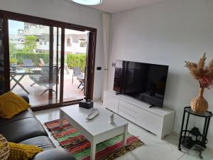 a living room with a couch and a flat screen tv at Cocoonly in San Juan de los Terreros