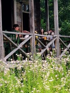 a group of people sitting at a table with flowers at Thea's Ethnographic Guest House in Nap'ich'khovo +31 photos