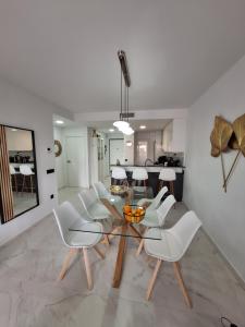 a dining room with a glass table and white chairs at Cocoonly in San Juan de los Terreros