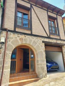 a house with a car parked in the garage at Casa Jacaranda in Arenas de San Pedro