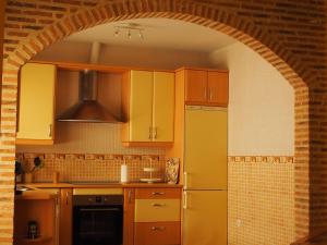 a kitchen with yellow cabinets and an archway at Casa Jacaranda in Arenas de San Pedro