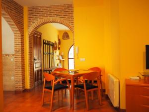 a dining room with yellow walls and a table and chairs at Casa Jacaranda in Arenas de San Pedro
