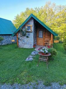 a cabin with a table and flowers in front of it at Gazela Bungalov 2 in Mojkovac +39 photos