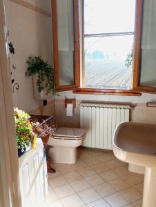 a bathroom with a toilet and a sink and a window at My DREAM in San Pietro in Campiano