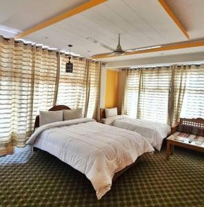 锡卡都Skardu view point hotel and huts的一间卧室设有两张床和大窗户