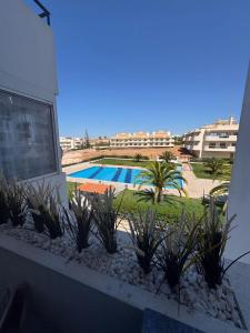 vistas a la piscina desde el balcón de un edificio en NS GuestHouse, en Armação de Pêra