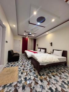 锡卡都Skardu view point hotel and huts的一间卧室配有两张床和椅子 更多6张照片
