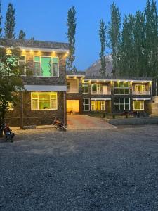 锡卡都Skardu view point hotel and huts的两辆摩托车停在房子前面的房子