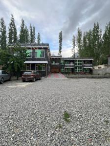 锡卡都Skardu view point hotel and huts的一座大型房子前面有汽车停放