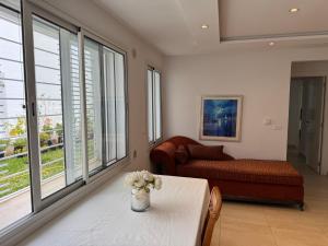 a living room with a table and a couch and windows at Appartement Peaceful Green Ennassr 2 in Ariana +16 photos