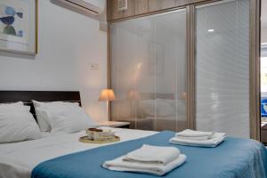 a bedroom with a bed with towels on it at Atlantis Apartments 50m From Makenzy Seafront in Larnaka +112 photos