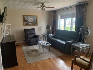 a living room with a blue couch and a chair at Long Beach Lookout Vacation Rental in Twillingate