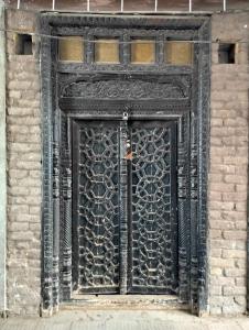 a black iron door on a brick building at DAN'S Crib in Karor