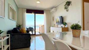 a living room with a glass table and white chairs at Marina suite in Peniscola