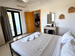a bedroom with a bed with towels on it at Pachia Ammos Falasarna in Falasarna
