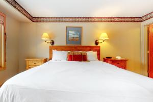 a bedroom with a large white bed and two lamps at Shoshone 1909 in Big Sky