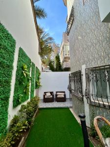 a courtyard with a green lawn next to a building at Pearl Haven Suite - Appartement F2 bord de mer in Dakar