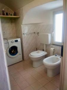 a bathroom with a toilet and a washing machine at Relax sulla spiaggia-appartamento incantevole in Gallipoli
