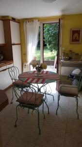 Una mesa y sillas en una cocina con ventana. en "Chambres d'Hôtes" Bord de Rance Au Rez-de-Jardin de la "Villa Cyrano", en Pleurtuit