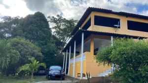 a car parked in front of a yellow house at Sítio Chã do Cajá in Sao Benedito do Sul