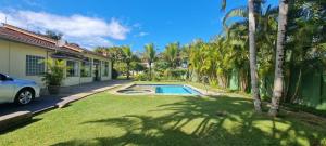 a house with a swimming pool in a yard at Encantadora Chácara com Piscina em Itanhaém in Itanhaém
