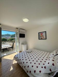 um quarto com uma cama e uma varanda com uma mesa em Apartmani Simona em Budva