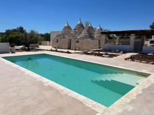 a swimming pool in front of a building at Luxury Trulli di Giulia, exclusive villa with private pool in Valle d'Itria Ostuni - BR, Puglia in Ostuni +74 photos
