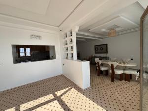Cette chambre blanche comprend une salle à manger et une table. dans l'établissement Sweety Mogador, à Essaouira