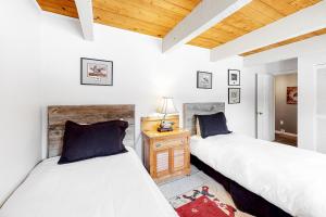 Dos camas en una habitación con paredes blancas y techos de madera. en Ducks Unlimited 173, en Big Sky 11 fotos más