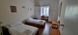 a small room with two beds and a window at Casa di Monica e Mauro in Rome