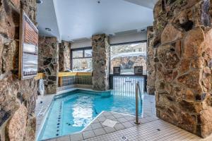 a pool in a room with a stone wall at Shoshone 1981 in Big Sky