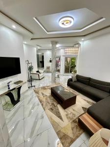 a living room with a couch and a tv at Pearl Haven Suite - Appartement F2 bord de mer in Dakar