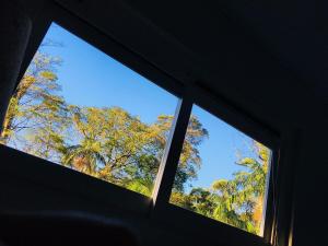 two windows in a room with trees in the background at Casa de la playa in São Paulo
