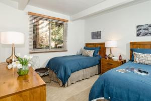 a bedroom with two beds and a table with two lamps at Aspen Alps in Aspen +1 photo